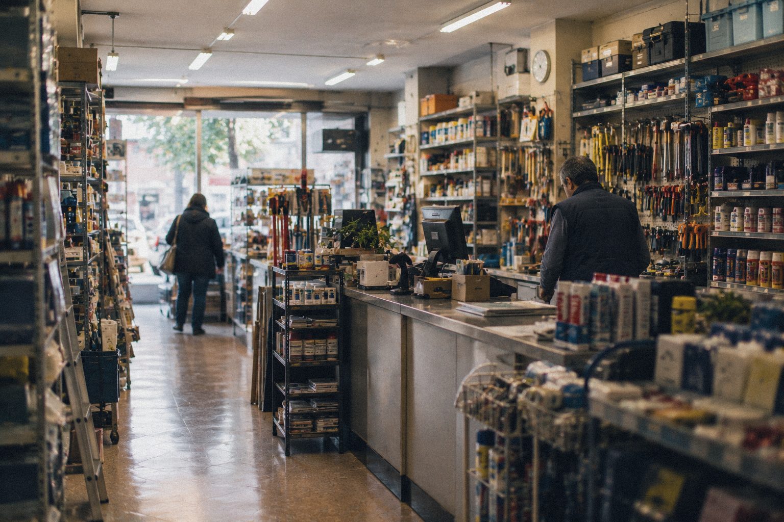 Interior de una ferretería de barrio con clientes